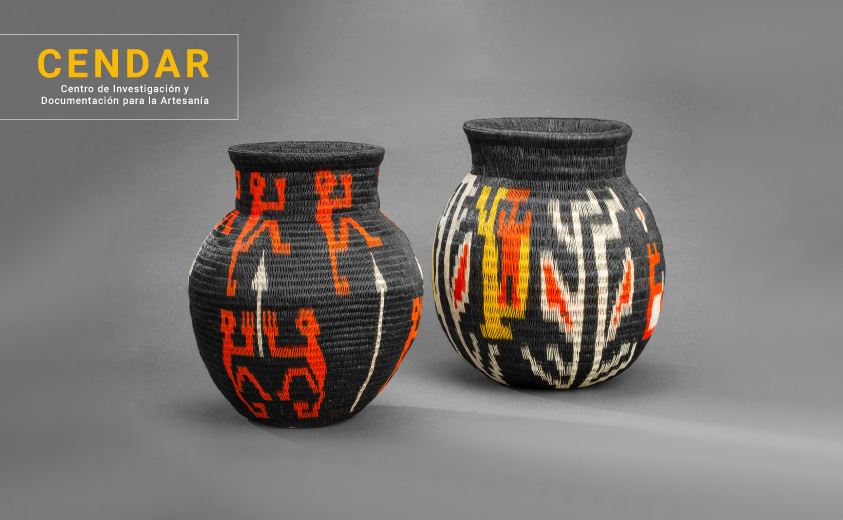Dos jarrones medianos tejidos en fibra de werregue, con los colores negro, rojo, blanco y amarillo. Imagen ilustrativa con el texto CENDAR. 
