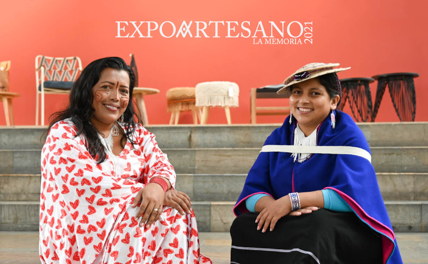 Fotografía de las artesanas Adeinis Boscan y Patricia Hurtado, quienes hicieron parte de la feria, sentadas en unas escaleras y con la marca Expoartesano.