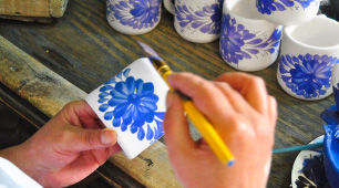 Artesana pintando pieza de cerámica